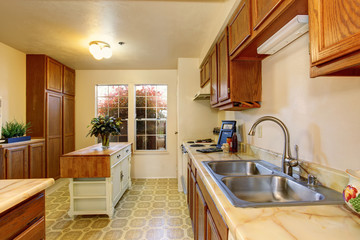 Traditional kitchen with tile floor, and small island.