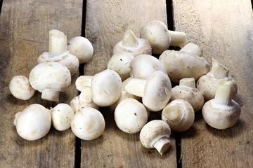 frische Champignons auf rustikalem Holzhintergrund