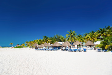 Caribbean beach with sun umbrellas and bed