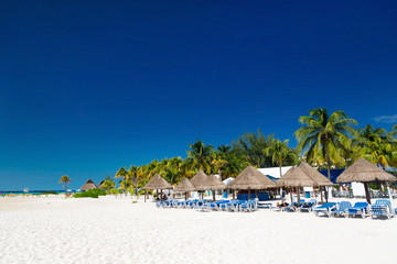 Caribbean beach with sun umbrellas and bed