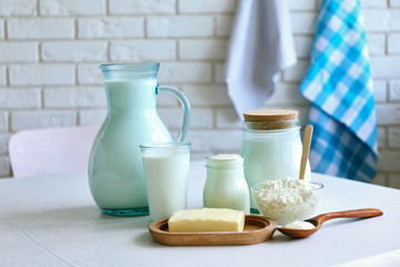 Dairy products on wooden table, on brick wall background