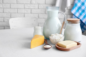 Dairy products on wooden table, on brick wall background