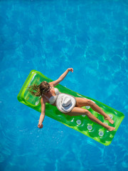 A girl is relaxing in a swimming pool