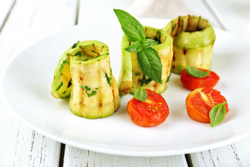 Grilled rolls of vegetable mallow in white plate on table, closeup