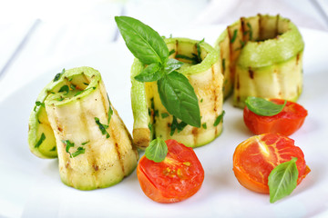 Grilled rolls of vegetable mallow in white plate on table, closeup