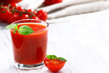 Glass of tomato juice on wooden table, closeup