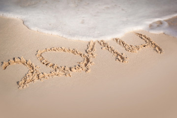 Inscription 2014 on sandy beach