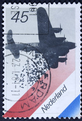 NETHERLANDS - CIRCA 1980: A stamp printed in Netherlands shows British Bomber Dropping Food, Dutch Flag, circa 1980