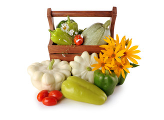 squash, zucchini and peppers in a basket on a white background
