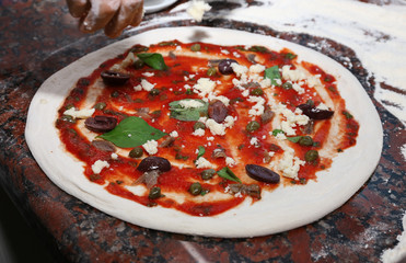 Preparing pizza on marble table, closeup