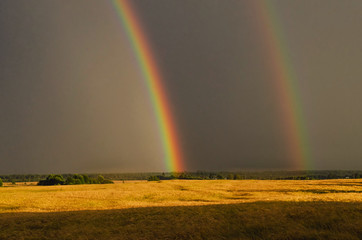 Primary and secondary rainbow over land. Russian nature