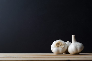 Garlic Bulbs Arranged on Wood with Black Background