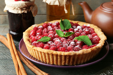 Tart with fresh raspberries, on wooden background