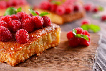 Fresh pie with raspberry on wooden table, closeup