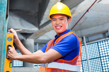 Builder or worker controlling wall on construction site