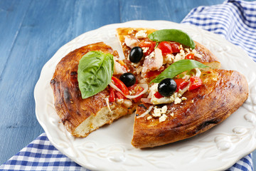 Pieces of homemade pizza on plate, on color table background