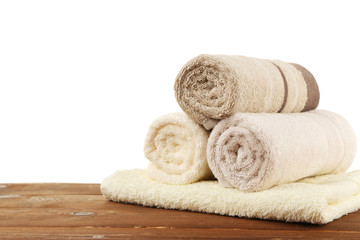 Fototapeta na wymiar Rolled bath towels on wooden table, closeup