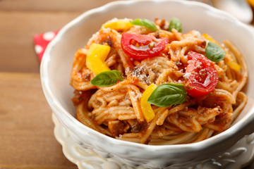 Homemade Spaghetti Bolognese with parmesan cheese in white bowl, on color wooden background