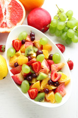 Fototapeta na wymiar Fresh fruit salad on white wooden table