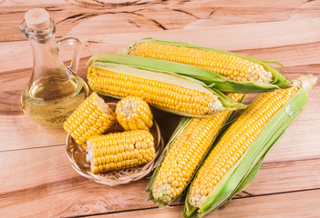 Freshly harvested corn on wooden background, corn oil