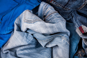 fashionable clothes. pile of jeans on a wooden background