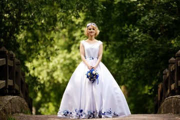 Bride in beauty wedding dress standing on bridge