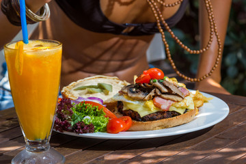 Woman eating a cheese burger at the summer lounge