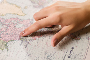 Female finger showing position on map