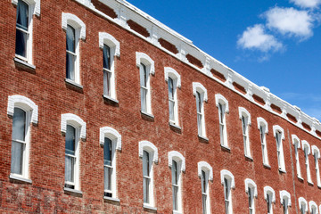 Two long lines of Colonial style windows on a red brick building