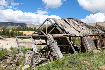 Falling over gray weathered abandoned mining shack outside Leadville, CO