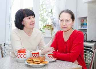 mature women  at   kitchen table with   cup of tea.