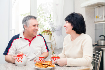 Obraz na płótnie Canvas couple in kitchen drinking tea