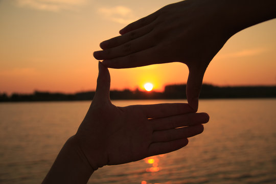 Hand frame against the sunset