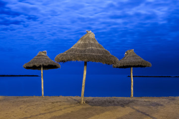 parasols on empty sandy moonlight beach 