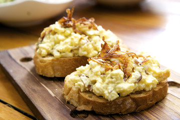 Slice of bread topped with egg mayonnaise and fried onion