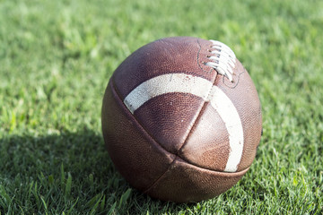 Close up of American football sitting on grass