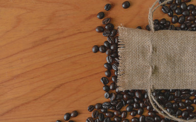 Sackcloth and coffee beans on old wooden table.top view point