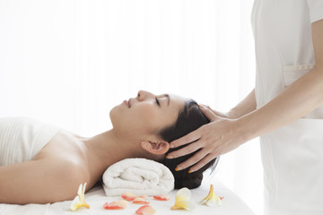 Beautiful Asian woman receiving head massage