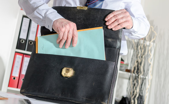 Businessman pulling out folders from his briefcase