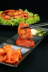 Chopsticks holding Korean chicken barbeque