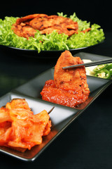 Chopsticks holding Korean chicken barbeque