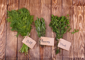 Fresh herbs hanging over wooden background