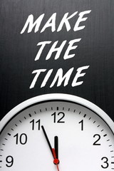 The phrase Make The Time in white text on a blackboard above a modern wall clock with the hands pointing at twelve midnight
