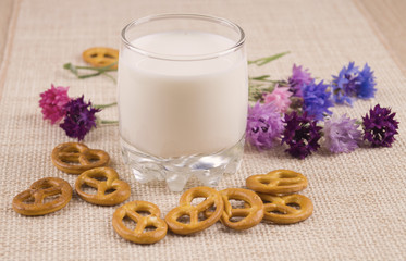Glass of milk and crackers and with cornflowers. Glass of milk and cookies. A glass of milk with blue flowers.