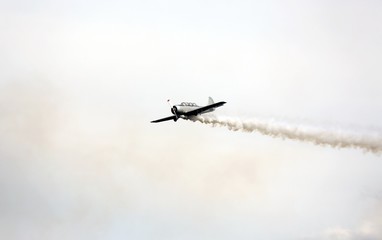 historic warplane with dark smoke from the engine malfunction