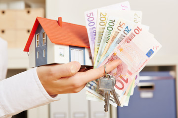 Hand mit Haus und Geld und Schlüssel