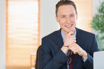 Happy businessman sitting at his desk