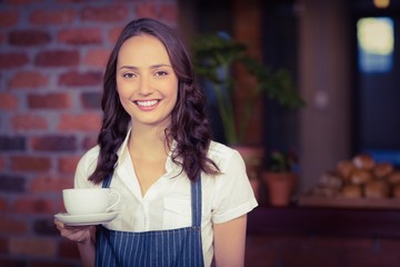 Pretty waitress holding a cup of coffee