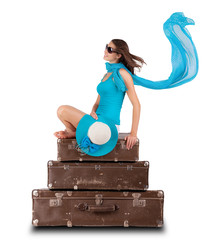 Pretty woman sitting on retro suitcases