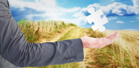 Composite image of businessman holding his hand out